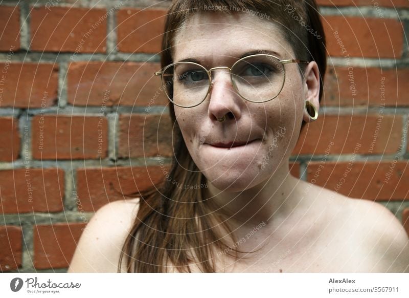 Portrait of a young woman in front of a brick wall Woman Youth (Young adults) already Strong Alternative great Piercing Skin Intensive Looking look watch Stand