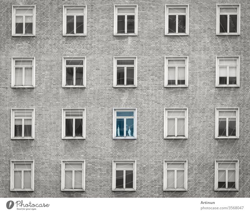 Glass window of skyscraper apartment or hotel building. Exterior brick wall of residential building. Architecture design. Window of building texture background. Gray and white vintage building.