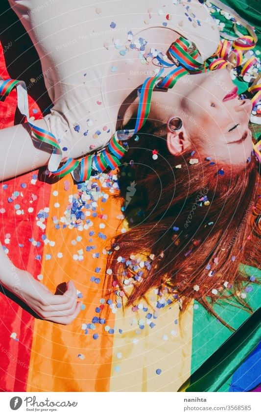 Young redhead woman celebrating gay pride day lgbti party flag rain bow homosexual lesbian color colorful outdoor social issue gender equality society free