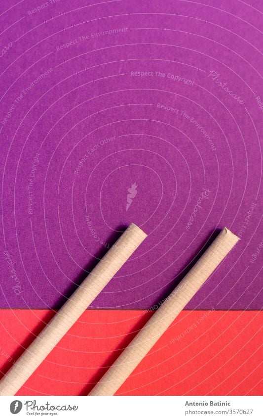 Two cigarettes from above laying flat on pink and purple backgrounds as a symbol of female smoking symbols copyspace two day graphic information mark habit