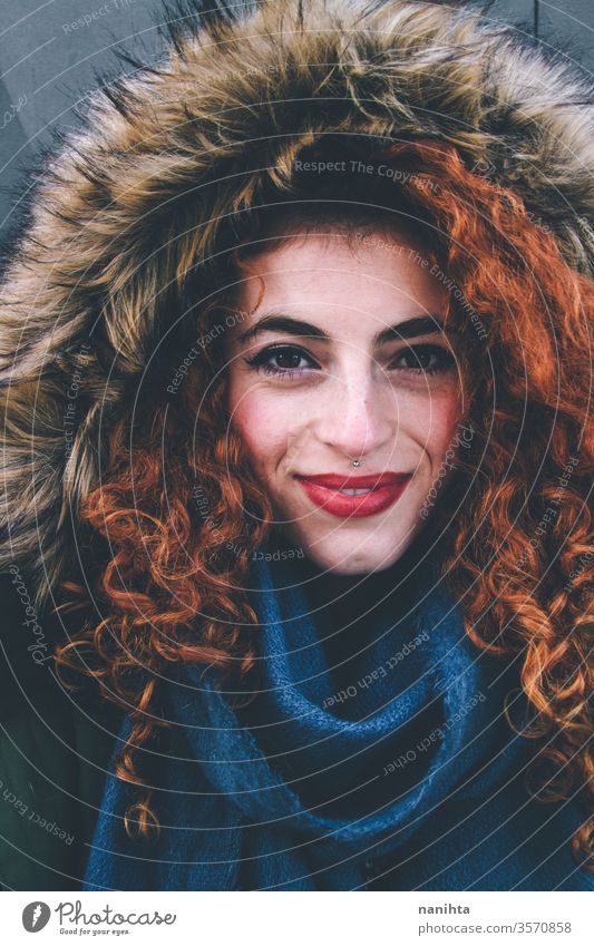 Beautiful portrait of an attractive redhead woman wearing winter clothes pretty face youth lifestyle curly hair ginger scarf warm model fashion trendy freckles