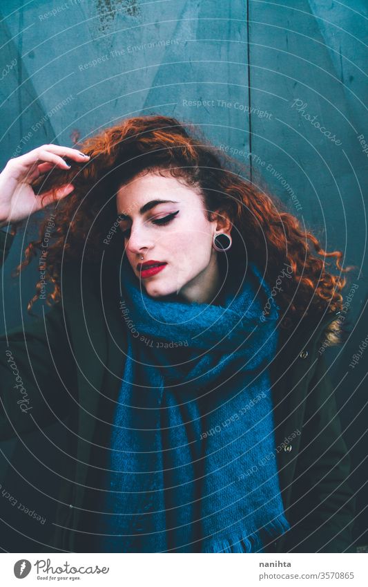 Beautiful portrait of an attractive redhead woman wearing winter clothes pretty face youth lifestyle curly hair ginger scarf warm model fashion trendy freckles