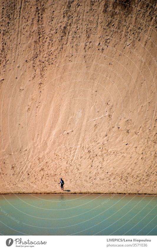 The lateral side of the dune stands like a huge wall beige color copy space day daylight desert hill hilly landscape lake nature people person sable sand shore