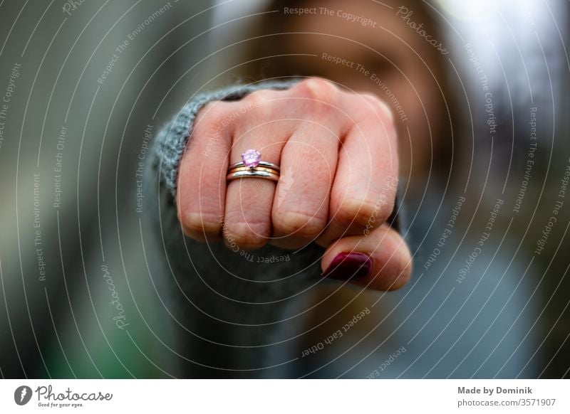 young woman stretches fist with ring into the camera by hand Ring sushi Woman Fist Jewellery Ring finger Nail polish Fingers Human being Colour photo Feminine