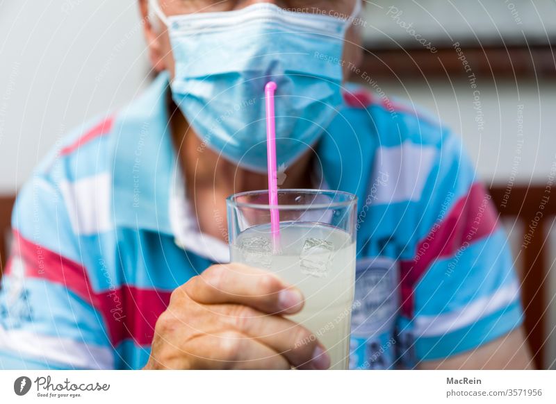 Man drinks with a straw through his mouth guard Mask corona covid-19 Sylt Majorca Norderney Fohr baltrum Wangerooge bunch Helgoland vacation holidays travel