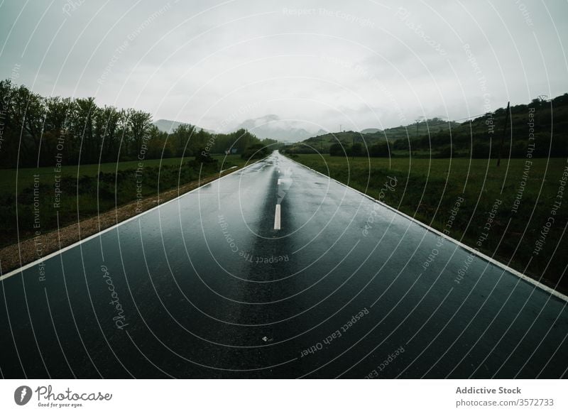 Countryside road among mountainous terrain with green forest countryside field windshield summer nature drive car valley speed direction highland trip landscape