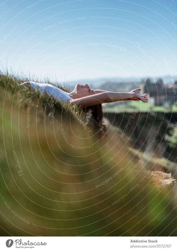 Dreamy woman lying on grass in mountains dreamy relax enjoy vacation travel tranquil summer female cantabria spain meadow sunny nature eyes closed idyllic