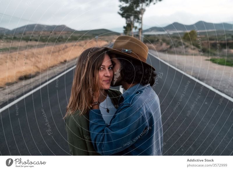 Couple hugging on countryside road couple date love sky cloudy trip together man woman affection casual asphalt romantic relationship girlfriend boyfriend