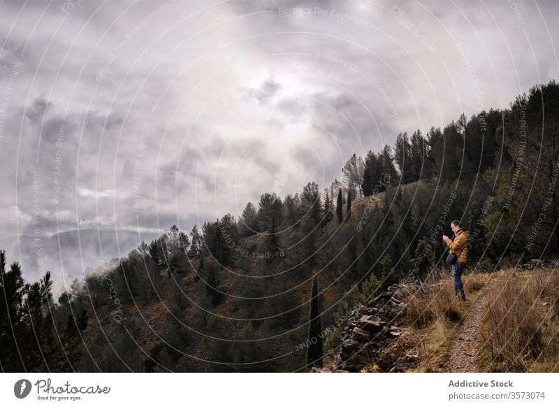 Unrecognizable hiker standing on country meadow and admiring view traveler landscape autumn lake shore mountain admire nature season adventure calm rest harmony