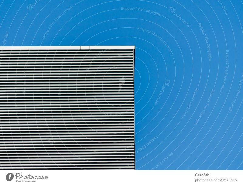 striped wall of a gray tall building against a blue clear sky abstract abstract background angle architecture black blank clean effect empty gelmetry house