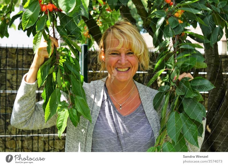 Woman under the cherry tree Cherry tree cherries Harvest Blonde hair Happiness Laughter sunshine Beautiful weather free time Garden fruit