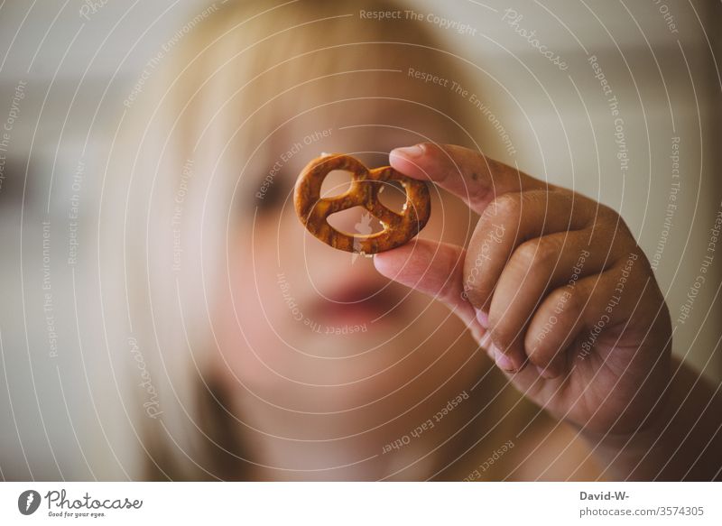 toddler with a pretzel in front of his face Child Pretzel Face Cute stop contemplating To hold on Delicious Eating pretzel with salt Laughter smile Playing