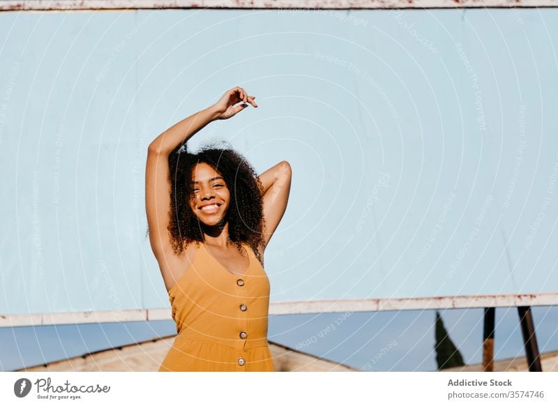 Young carefree ethnic woman on street against empty big board in city billboard dress happy advertising satisfied banner smile mockup appearance delight female