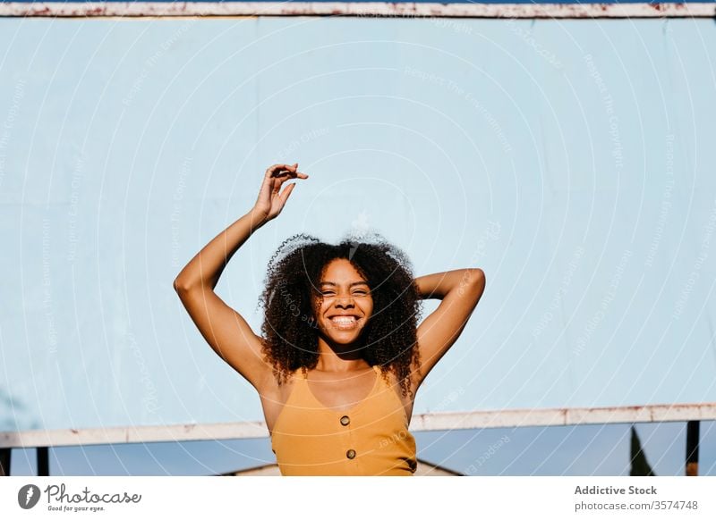 Young carefree ethnic woman on street against empty big board in city billboard dress happy advertising satisfied banner smile mockup appearance delight female