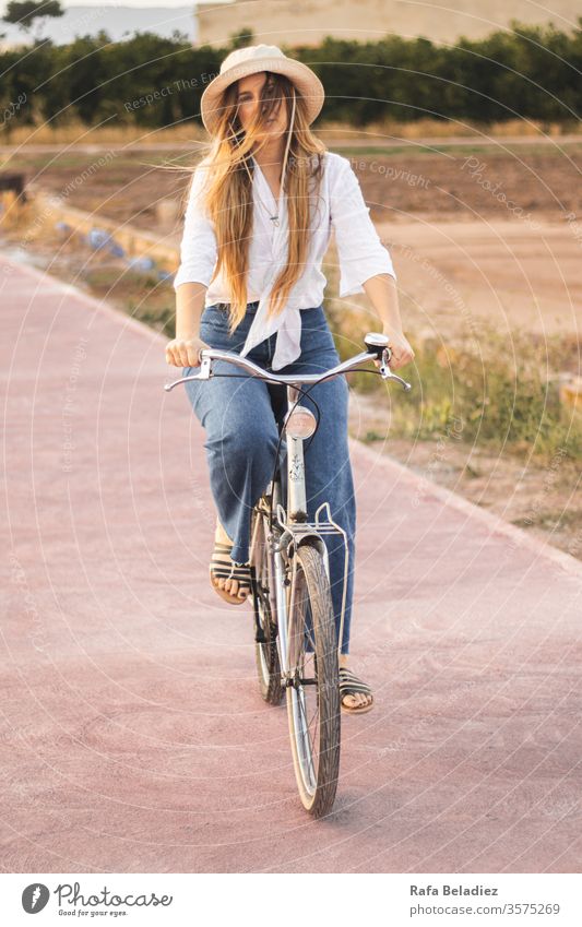 Young girl riding a bicycle through nature Lifestyle Bicycle Girl Ride Nature Wild Vintage Blonde Woman