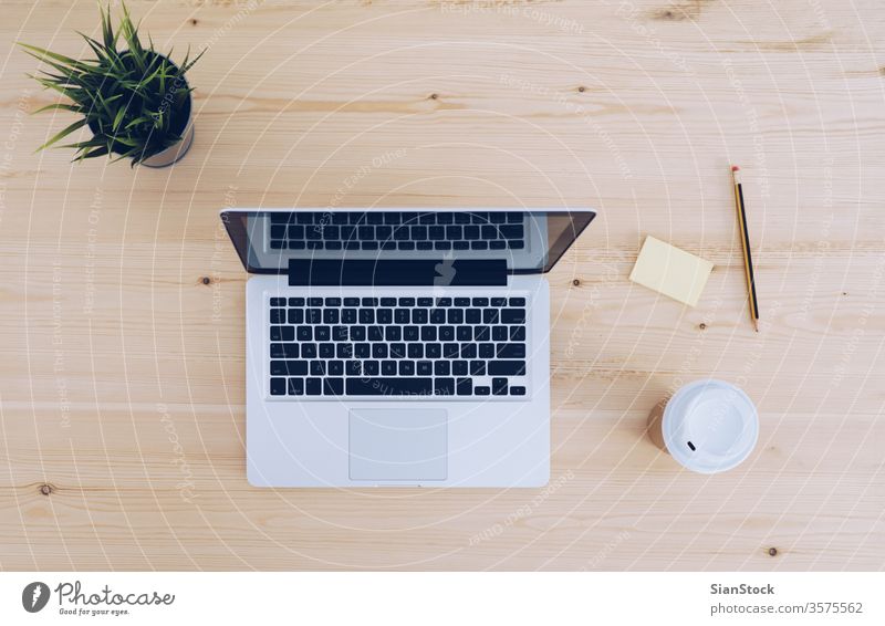 Top view of wooden workplace with coffee, laptop above background blank business computer copy copyspace cup desk keyboard message note notebook office pencil