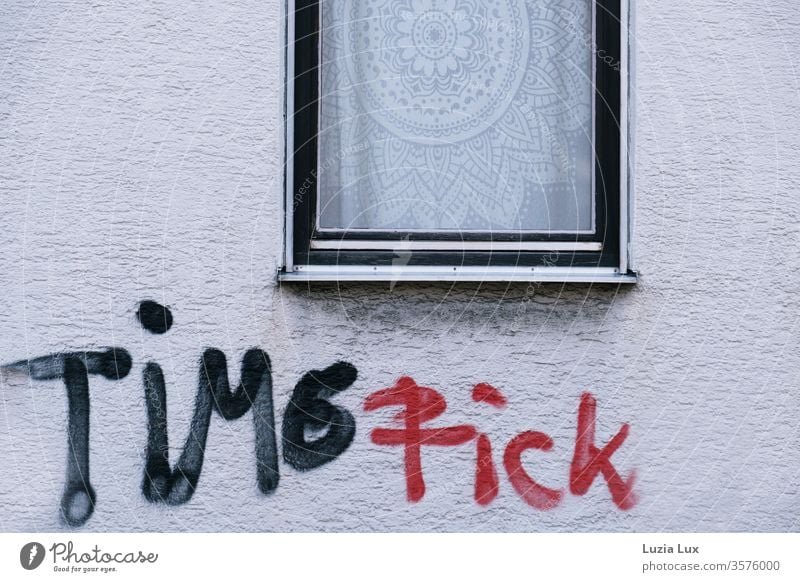 Time fuck: Graffiti black red under a window with a striking lace curtain Window Facade roughcast White Red Black Town Hideous urban Exterior shot Deserted