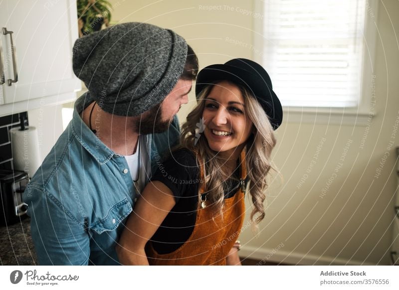 Happy couple embracing standing in the kitchen at home embrace relationship positive hipster style boyfriend affection fondness together love girlfriend partner