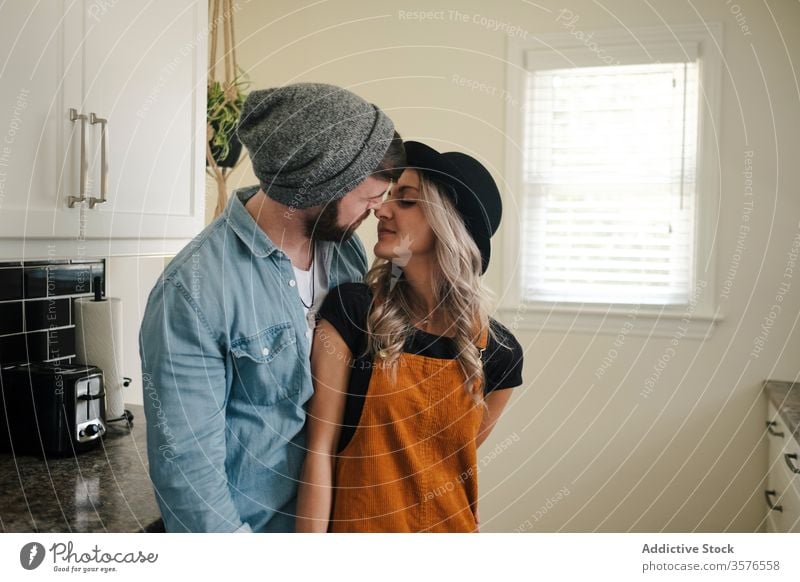 Happy couple embracing standing in the kitchen at home embrace relationship positive hipster style boyfriend affection fondness together love girlfriend partner