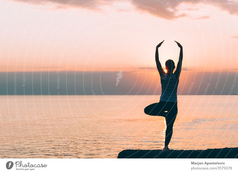 Young woman doing yoga on the beach sport sporty stretching athletic recreation training workout healthy fit young exercise lifestyle fitness active energy