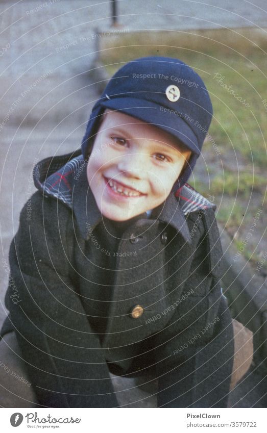 A little boy in a cap laughs into the camera Boy (child) Child Playing Face Infancy Happiness Joy Human being Laughter Retro children