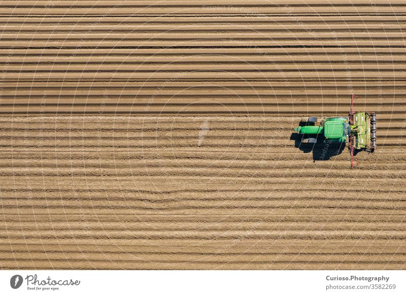 Aerial view of farming tractor plowing and spraying on field.  Agriculture. View from above. Photo captured with drone. aerial machine agriculture harvester