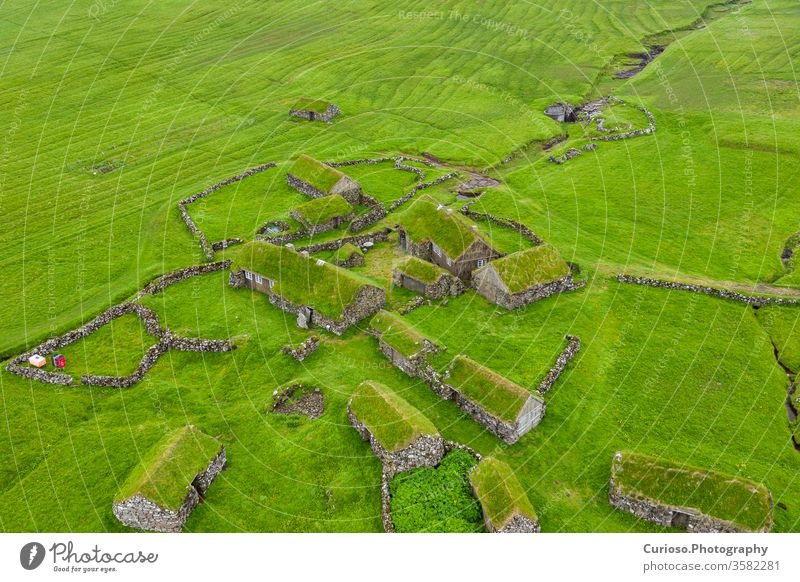 Aerial view of fishing village in Koltur island. Faroe Islands. Green roof houses. Photo made by drone from above. Nordic natural landscape. sea wooden koltur