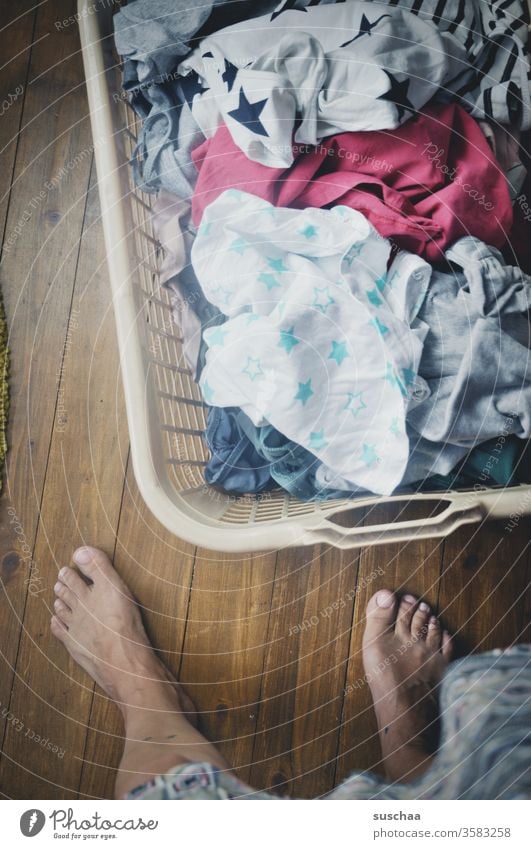 washday | woman stands in front of a laundry basket filled with dirty laundry Woman Housewife housework gender roles Household Mother Laundry Laundry basket