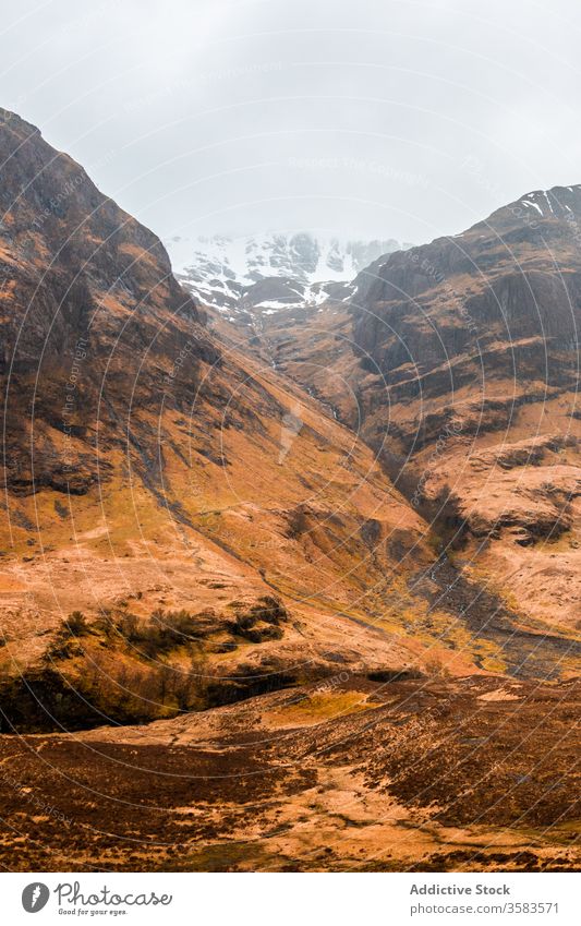 Remote road in endless mountainous valley highland rock nature landscape countryside route ridge range terrain scotland glen coe sky cloudy grass spring travel