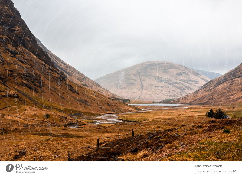 Remote road in endless mountainous valley highland rock nature landscape countryside route ridge range terrain scotland glen coe sky cloudy grass spring travel