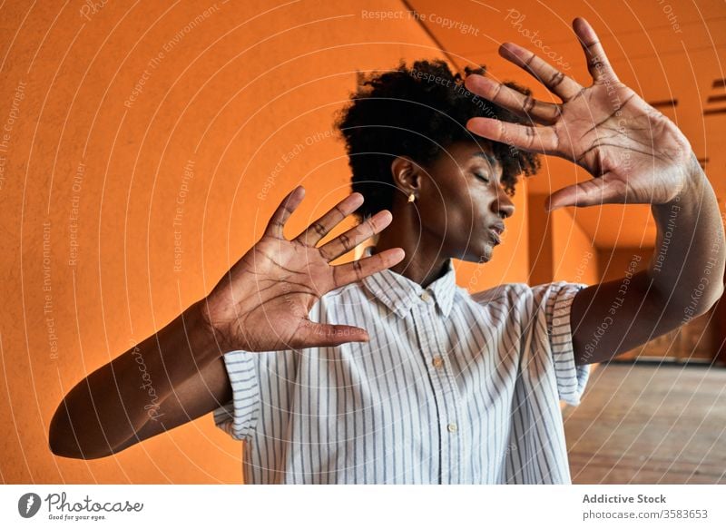 Serious black woman with hands raised protesting and trying to stop violence prevent against gesture sign dissuade objection concept renouncement refuse serious