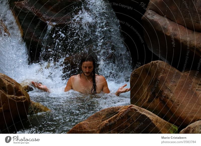 Meditating under a cascading waterfall harmony with nature meditation new age rebirth power power of water power of nature healing in nature back to nature