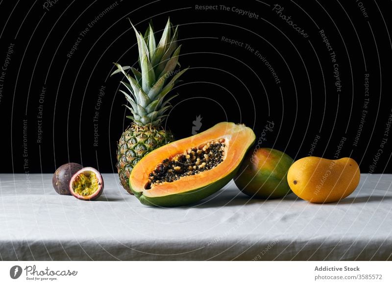 Still life with tropical fruits exotic pineapple papaya mango passion fruit hawaii black ingredients natural organic food green colorful juicy sweet ripe