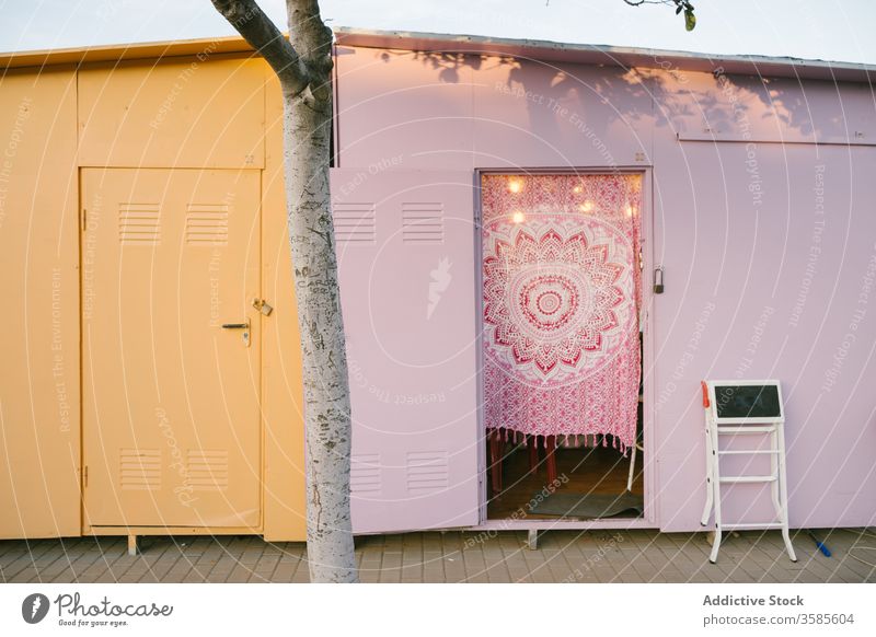 Colorful utility buildings on pavement ground yellow pink metallic weathered urban area tree colorful composition sunny summer day clear sky blue sky exterior