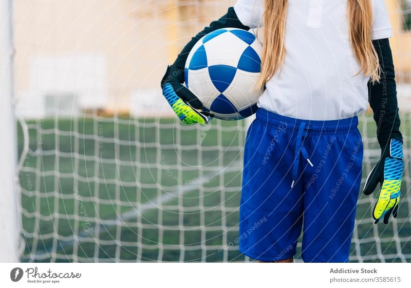 Crop young female player with ball in football arena at sports stadium girl soccer field uniform child kid club childhood athlete equipment preteen schoolgirl