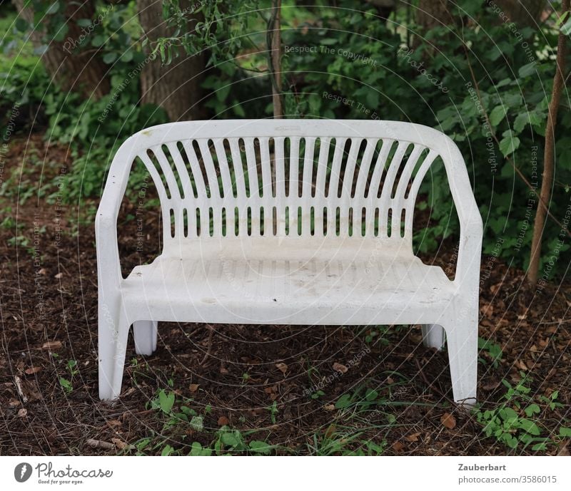 White plastic garden bench stands under trees on forest ground Bench Garden bench Plastic huts leaves Forest forest soils Sit Rest shape Hideous