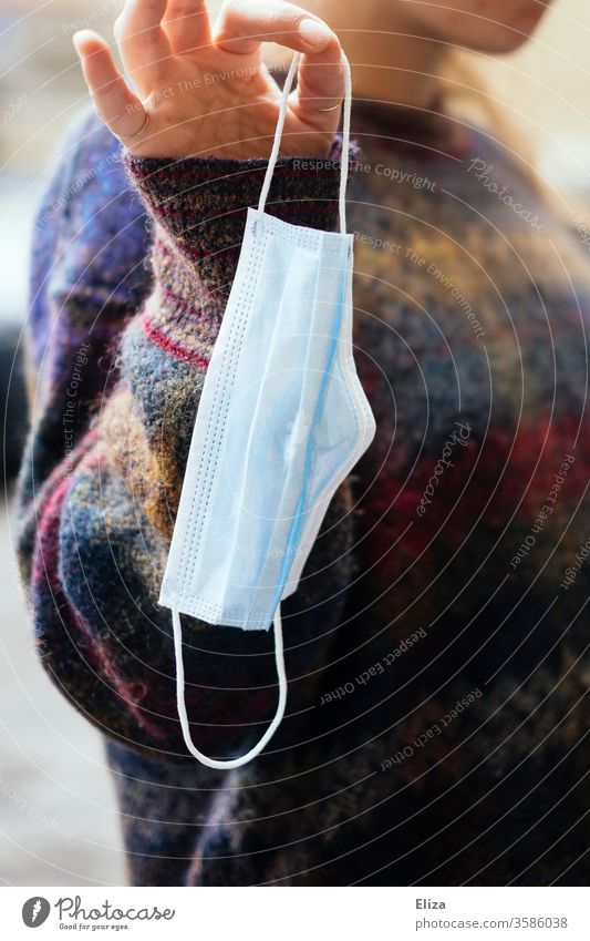 A young woman holding a medical mask in her hand Mask Face mask Exasperated Woman youthful Fingers stop by hand move out moved out Mask obligation mns