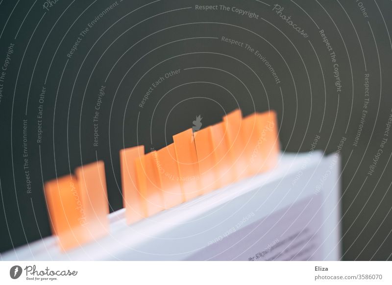 A book with many sticky notes and sticky markers to mark pages Confusing Adhesion marker page marker Orange Education accentuate Literature Memory Markings Book