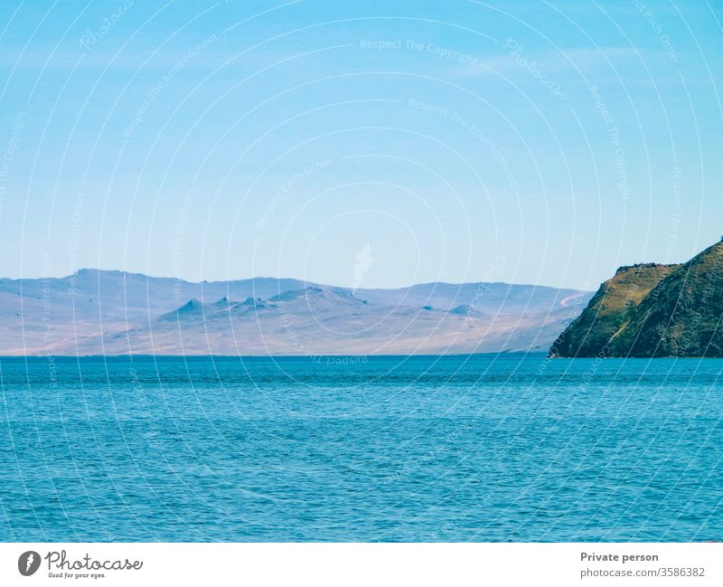 Blue sea, cloudless sky and mountains on a sunny summer day. Lake Baikal is the deepest lake on the planet, the largest natural reservoir of fresh water blue