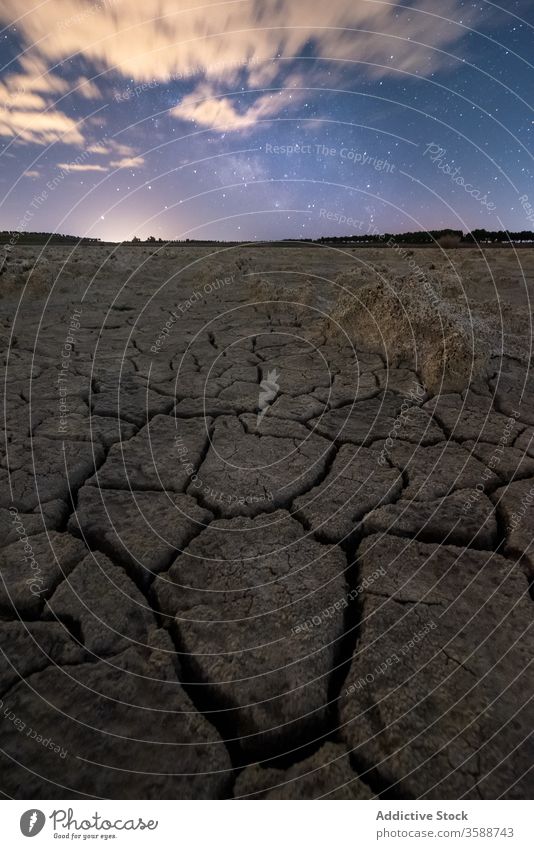 Dry cracked terrain under cloudy sunset sky drought dry ground nature desert environment land hot ecology lifeless background texture heat landscape global warm