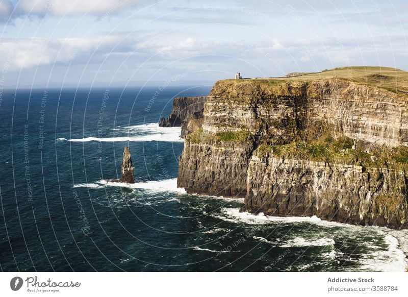 Rocky cliff above ocean foamy waves giant remote wild landscape scenic huge gigantic seaside ireland heaven coastline distance sky nature power height