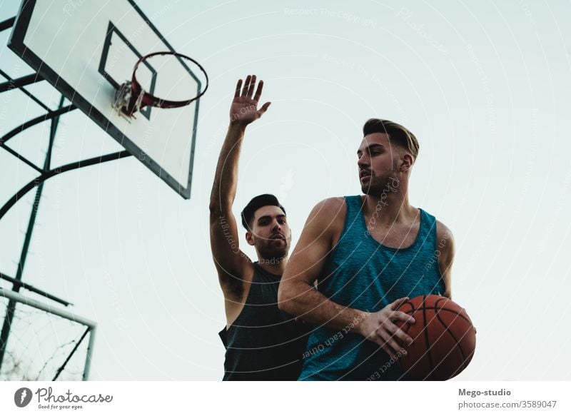 Young basketball players playing one-on-one. game youth sport court male young team together active action playground exercise men friendship jump happy athlete