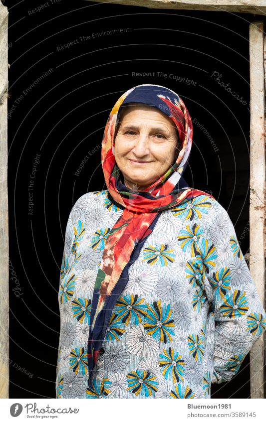 Portrait of a Muslim woman in traditional cloth in front of wooden door frame taleshi local rural countryside travel elderly indoor building lifestyle people