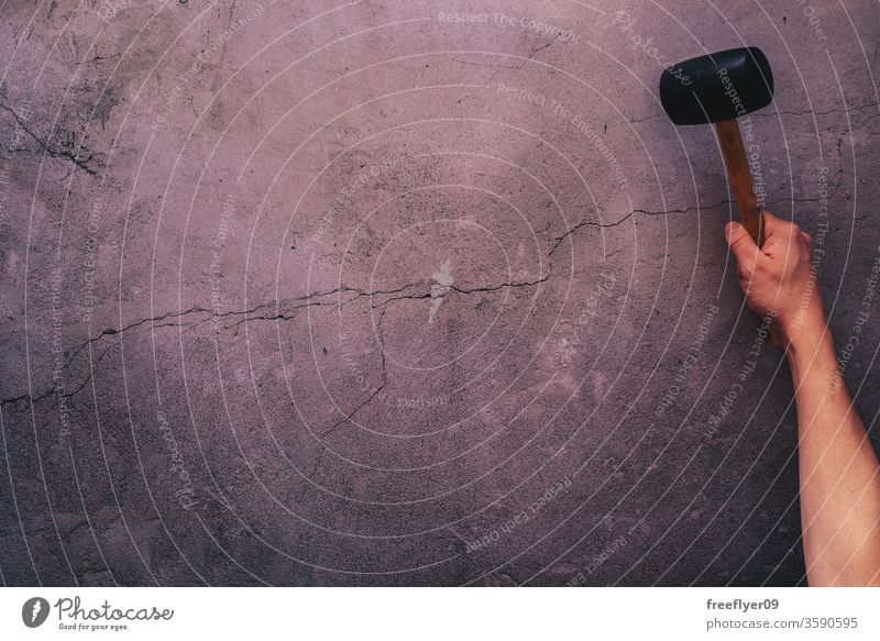 Hand holding a hammer hitting a cracked concrete background violence hand flat lay flatlay copy space copyspace still still life from above objects mockup