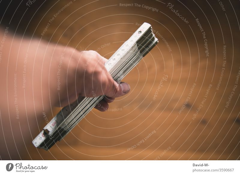 Handicraft - Man holds a folding rule in his hand Metre-stick Craft (trade) Craftsperson Home improvement Build Planning Measure measure measure again