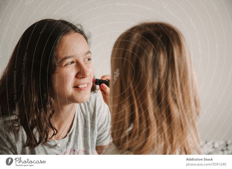 Adorable sisters with painted faces at home pastime girl sibling having fun together playful relationship kid teen little childhood cute teenage bonding cozy