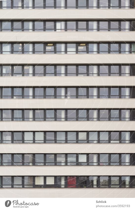 Facade of an office building with many frontal windows Office building Frontal Day neon lamps Window Many Modern squares Rectangles Aluminium windows Floors