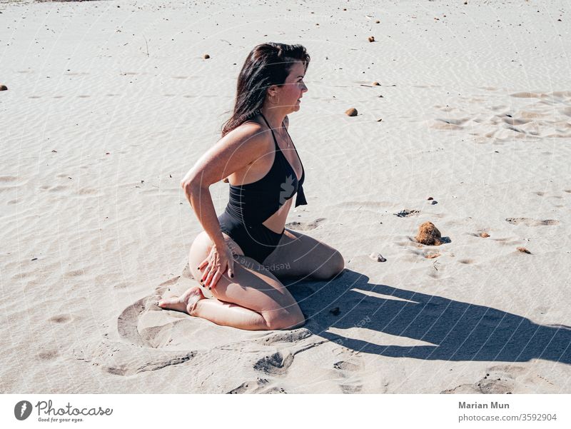 girl with swimsuit sitting on the sand chica bañador arena playa pose tomando el sol rayos de sol bronceado verano calor vacaciones