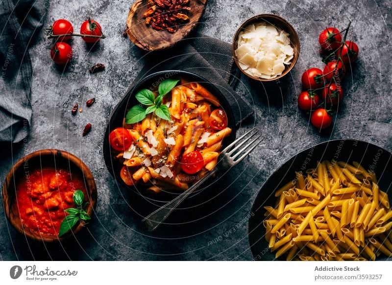 Appetizing penne with arrabiata sauce and fresh tomatoes on table pasta gastronomy ingredient parmesan italian tradition basil food bunch product sun dried meal