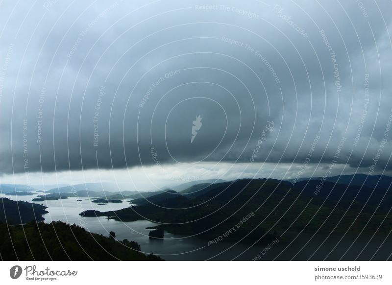 Landscape of lake Bunyonyi and big dark clouds sky rain thunderstorm Experiencing nature hills water